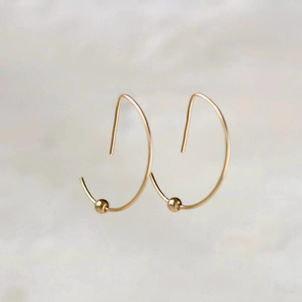 Gold hoop earrings on white background.