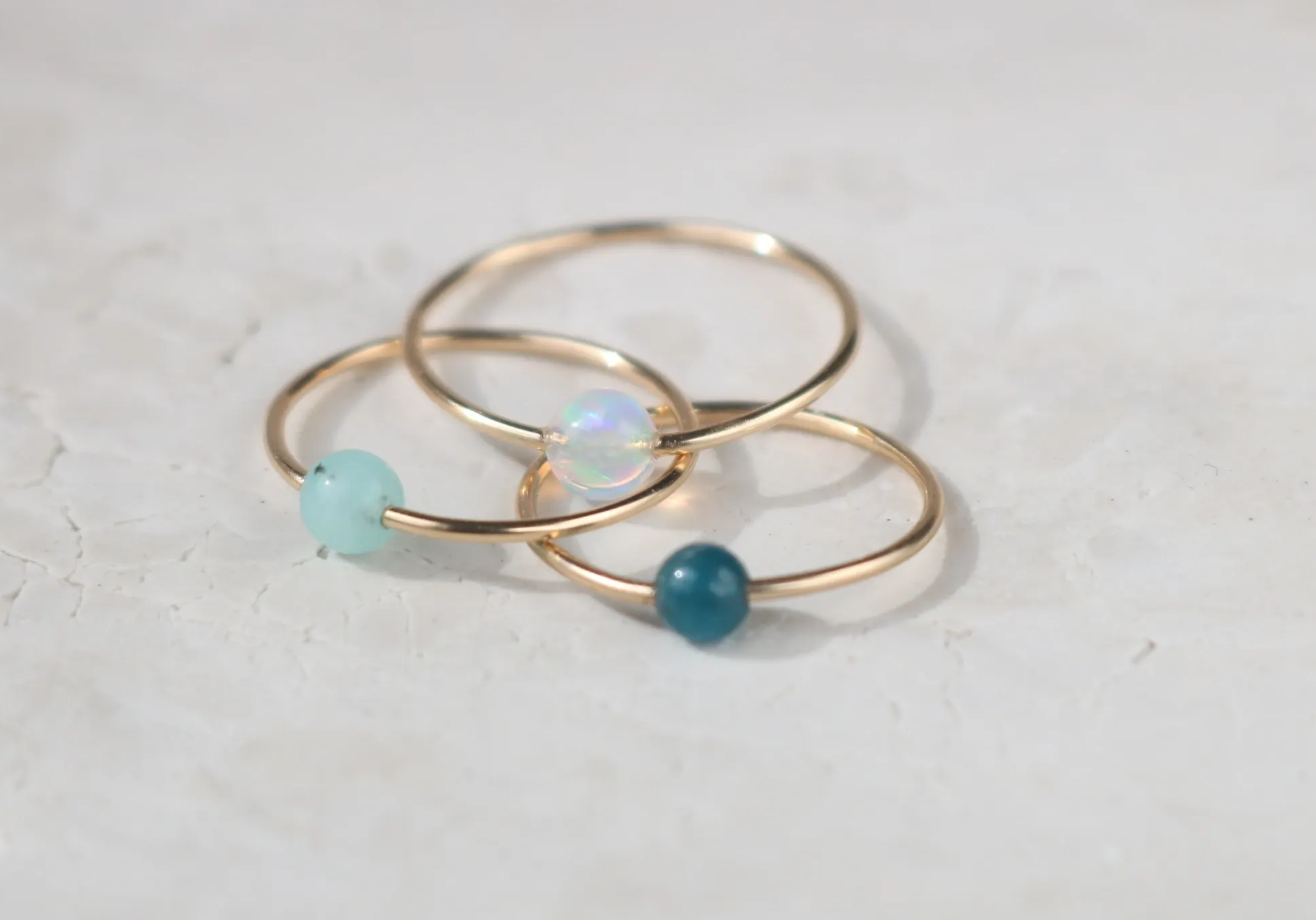Three gold rings with small gemstone beads