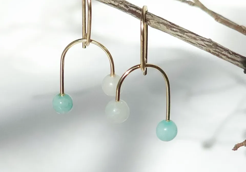 Delicate gold U-shaped earrings with green beads